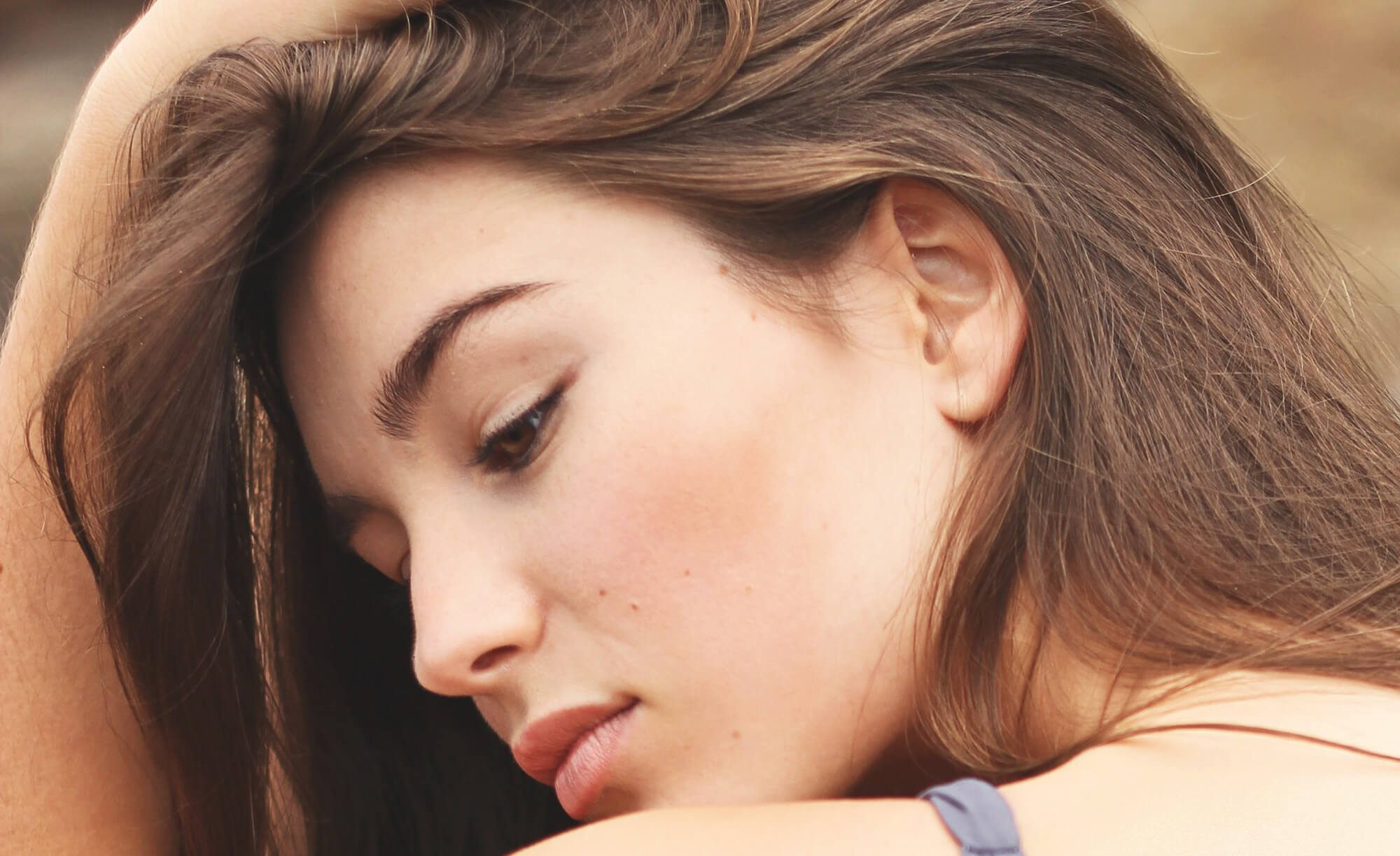 A young woman tilts her head to show excellent skincare.